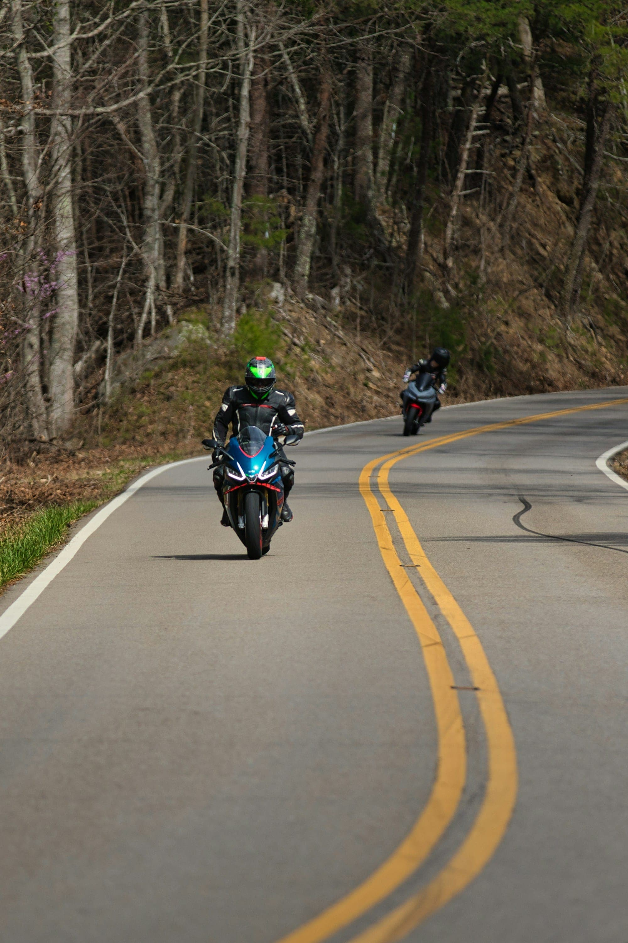 Two riders leaning through a curve on the Tail of the Dragon, Tennessee