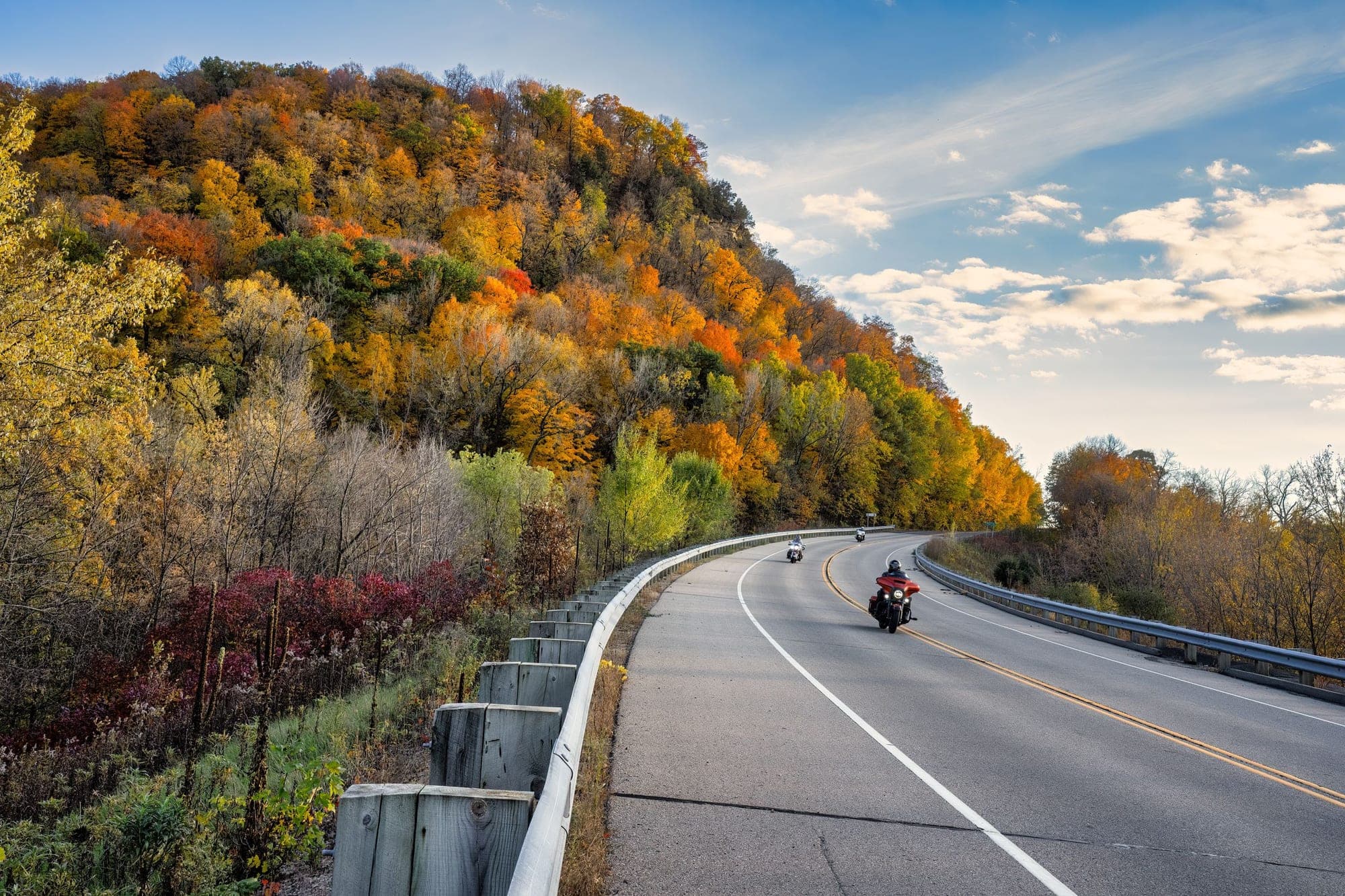 Motorcycles riding the Great River Road under autumn bluffs near Stockholm, Wisconsin