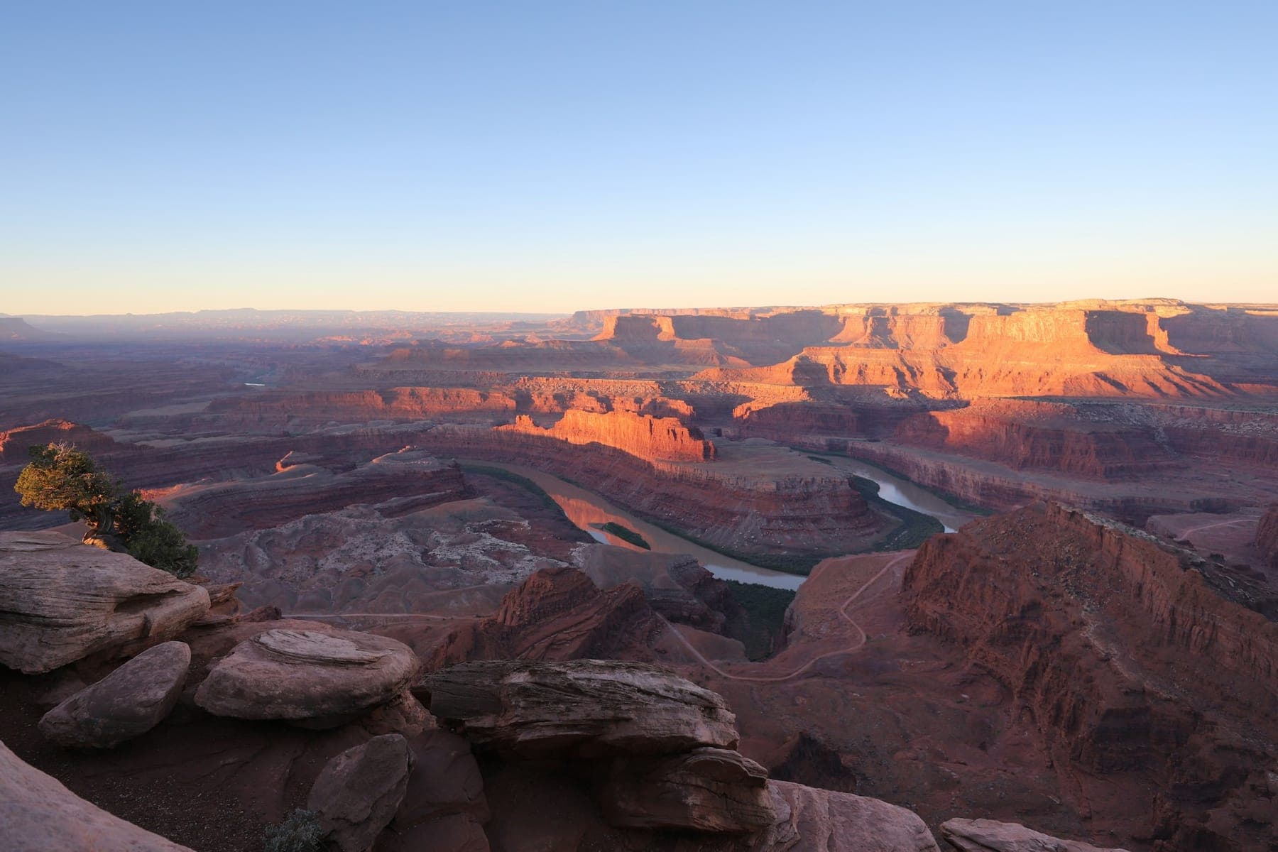 The Colorado River gooseneck far below the rim at Dead Horse Point at sunset