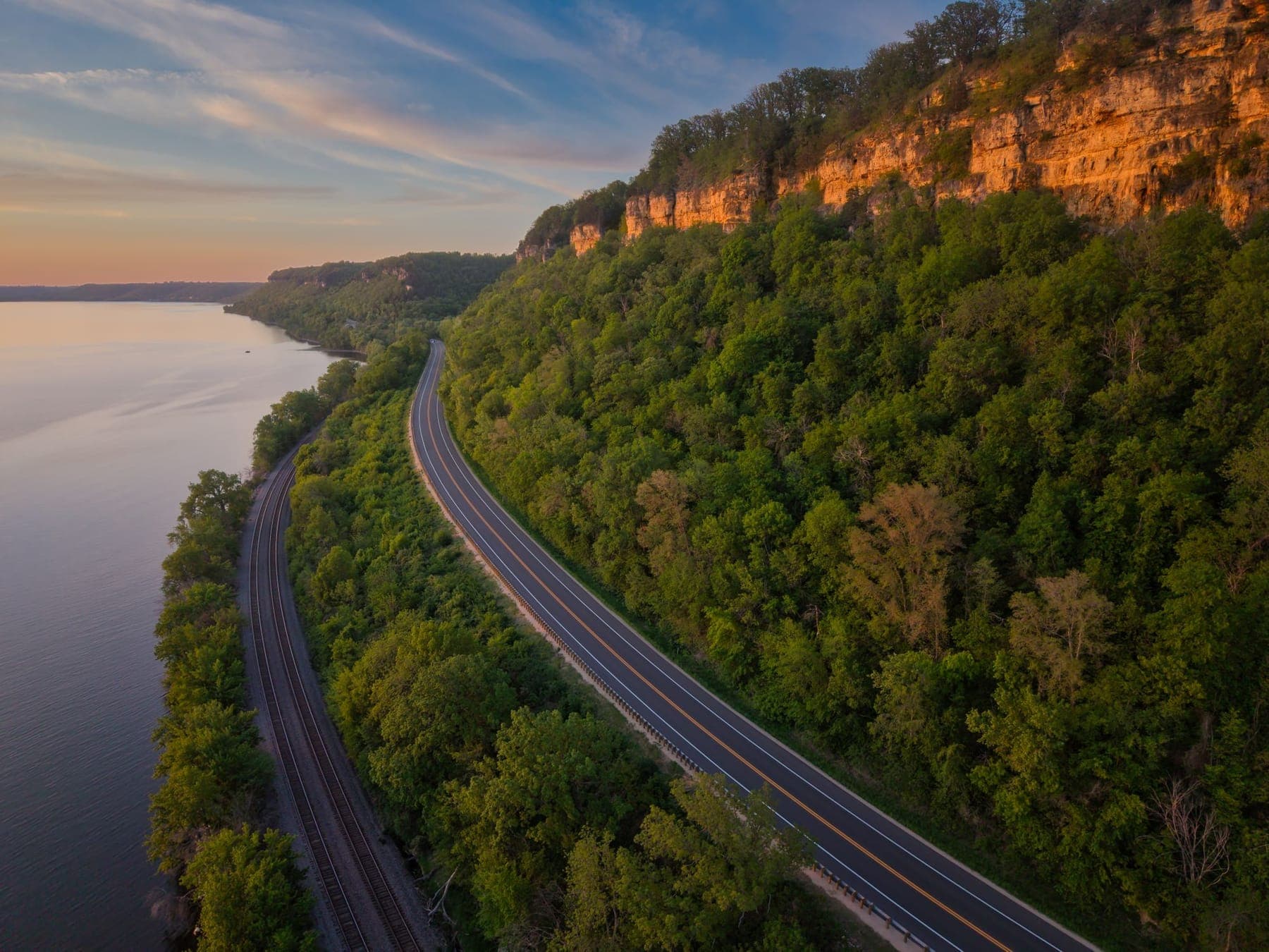 The Great River Road curving beneath a limestone bluff at Maiden Rock, Wisconsin, at sunset