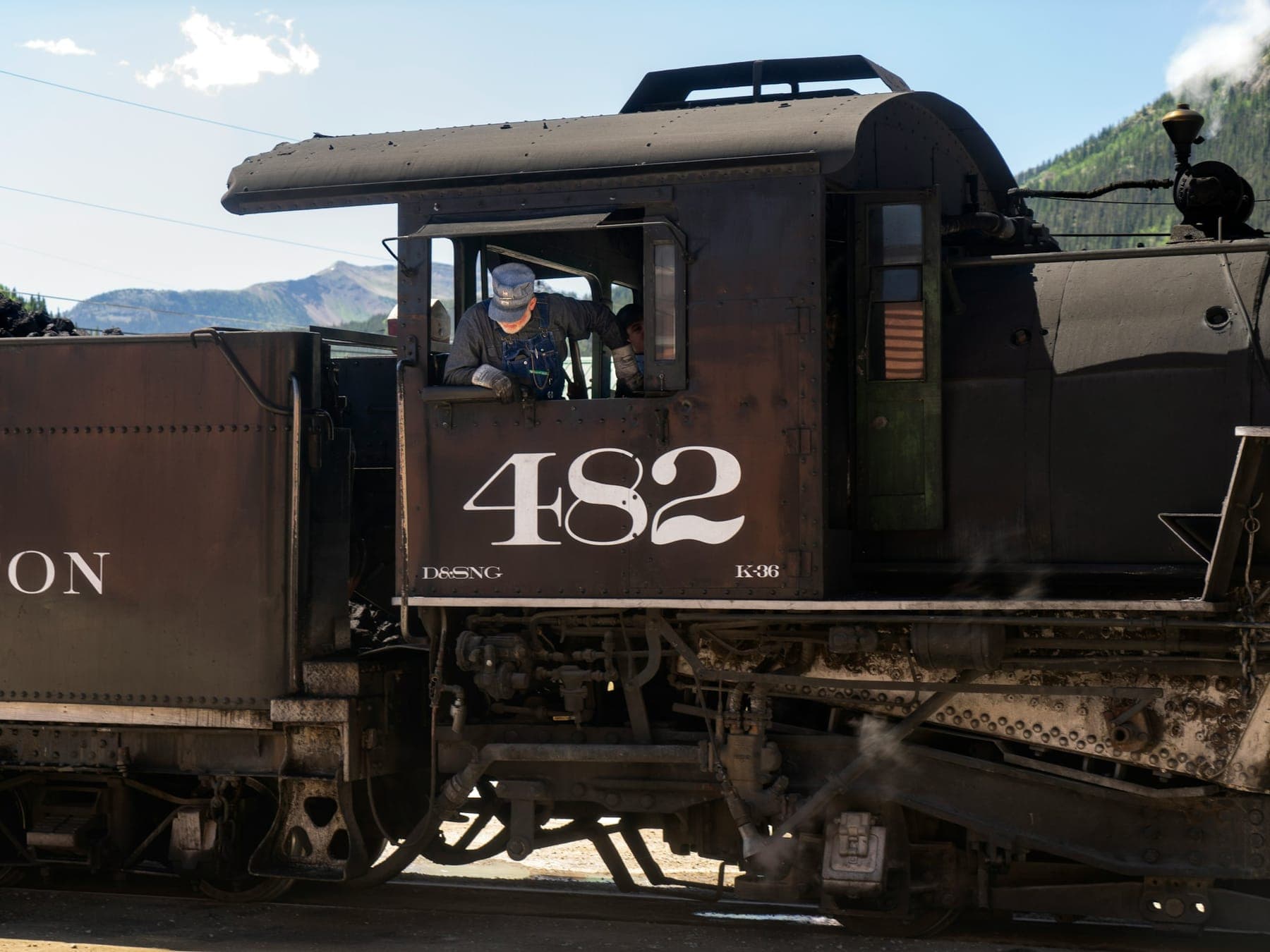 An engineer at the controls of a Durango & Silverton narrow-gauge steam locomotive in Silverton